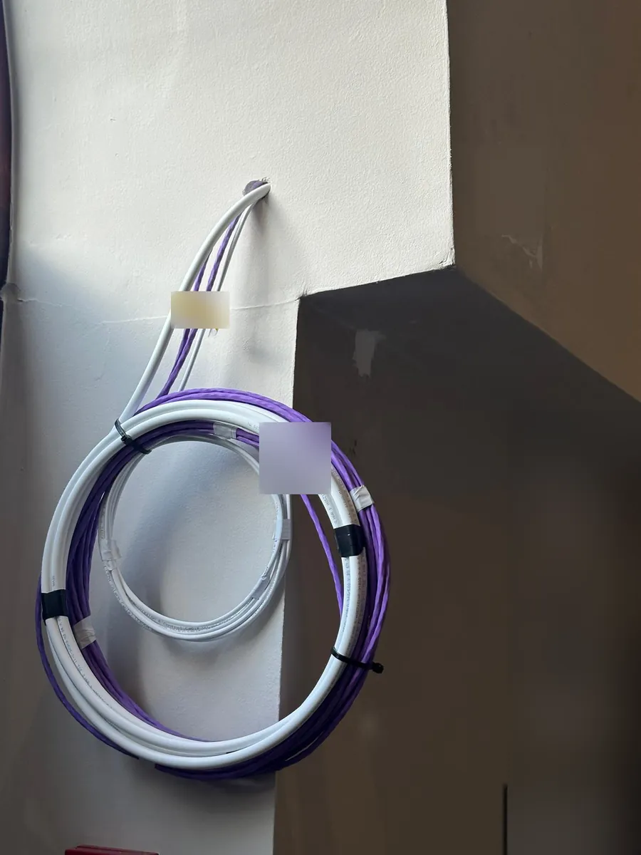 Fibre and data cable coiled and labelled in a common hallway